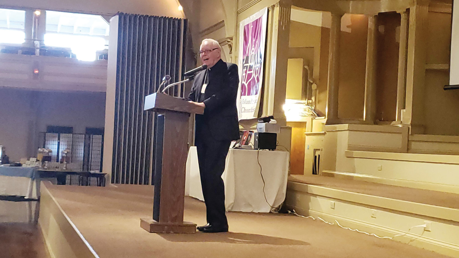 Father Raymond Malm addresses the audience at the ninth annual Heroes of Faith Breakfast after receiving the Reverend Hebert Bolles Life Achievement Award from the Rhode Island State Council of Churches.